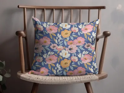 Blue decorative pillow with a floral pattern of pink and orange flowers.