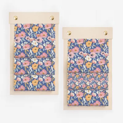 Fabric swatches with floral pattern of pink, white, and orange flowers on blue.