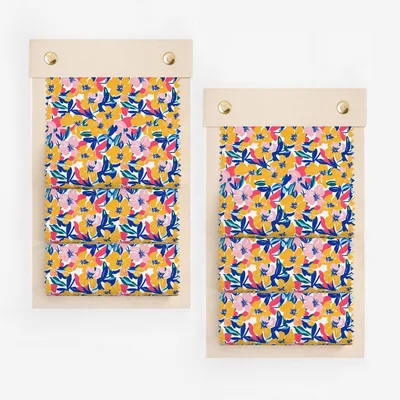 Two fabric swatches with a vibrant floral pattern of pink, blue, and yellow flowers.