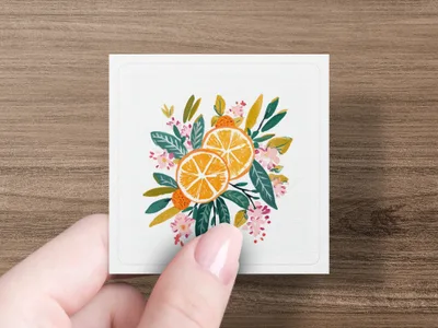 Two orange slices with green leaves and pink flowers.