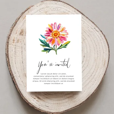 Card with floral illustration and "You're invited" text on wood slice.
