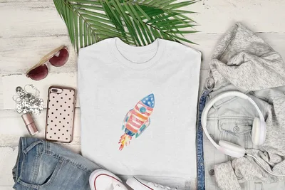 White t-shirt with watercolor rocket graphic, denim jacket, jeans, sunglasses, and headphones.