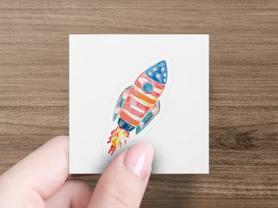 Watercolor rocket with American flag design launching against a white background.