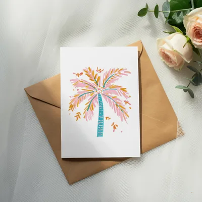 Card with colorful palm tree illustration on brown envelope with roses.