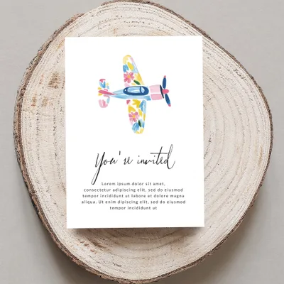 Invitation card with colorful floral airplane and "You're invited" text.