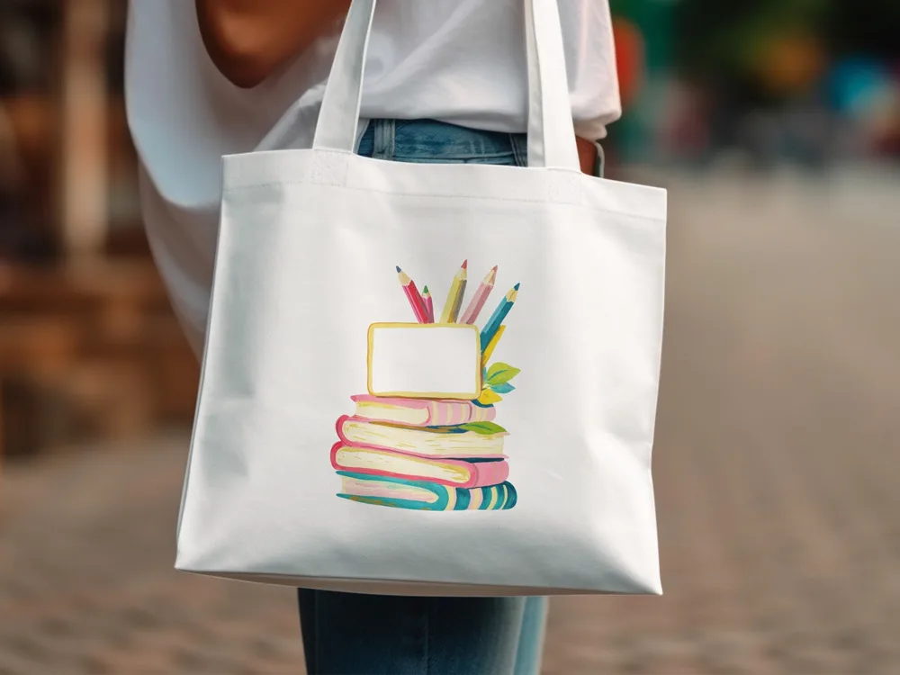 Tote bag with stack of colorful books and pencils in a blank frame.