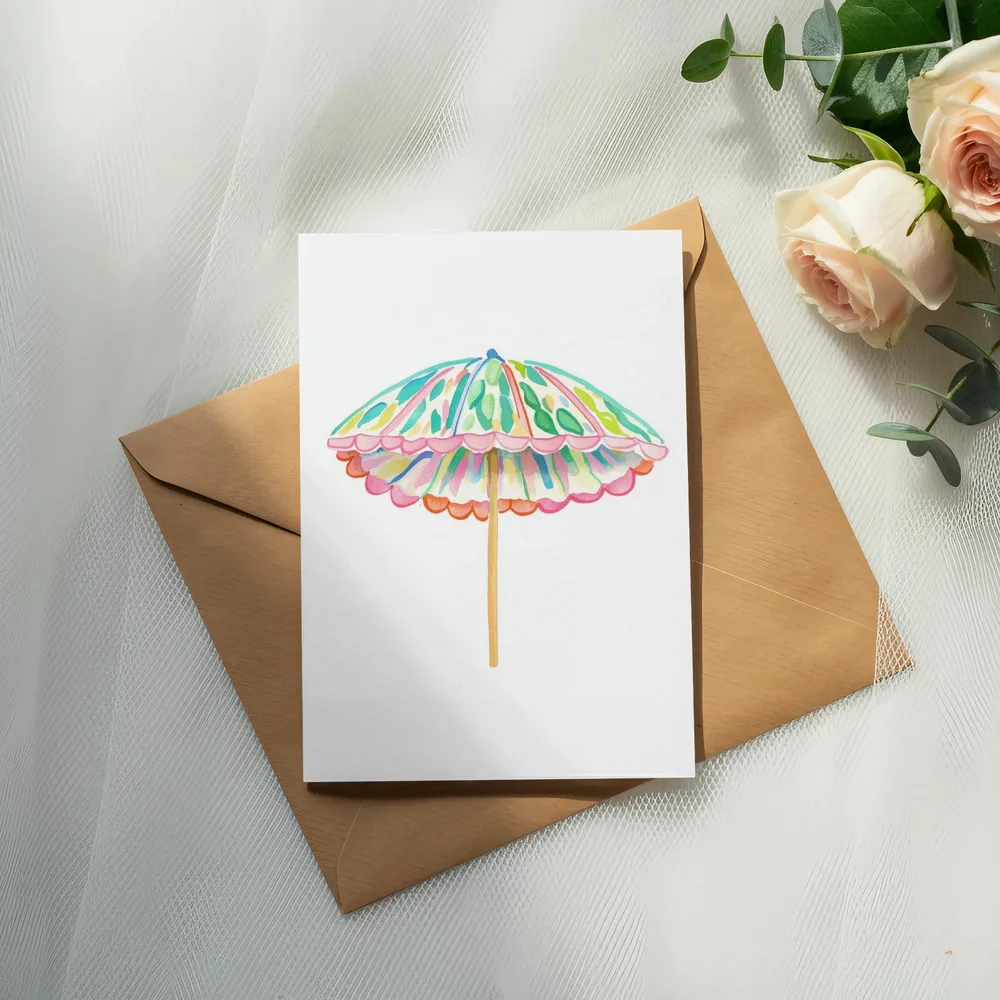 Watercolor beach umbrella on a card with an envelope and roses.