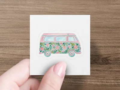Pink and turquoise floral camper van sticker held by a hand.