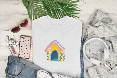 White t-shirt with a colorful cartoon doghouse illustration.