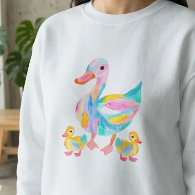 Watercolor duck family with colorful abstract patterns on a white sweatshirt.