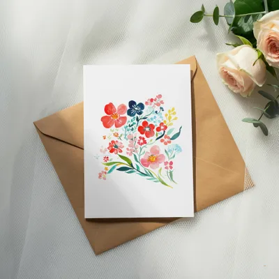 Watercolor floral bouquet on a card atop a brown envelope.
