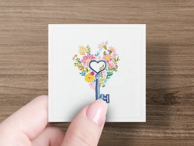 Floral heart key design on a white card held by a hand.