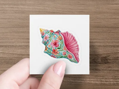 Seashell sticker with coral and floral pattern held by a hand.