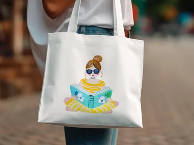 White tote bag with watercolor illustration of a girl reading a book.