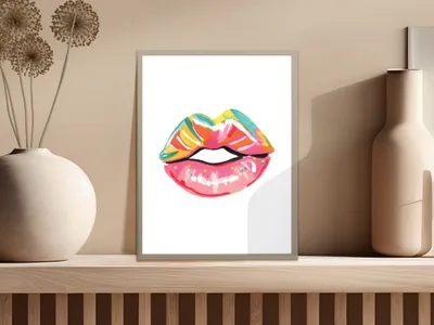 Colorful abstract lips artwork in a white frame on a shelf.