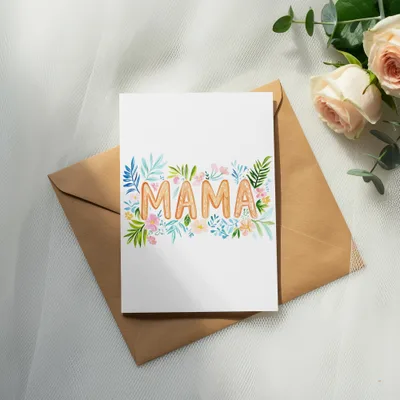 Card with floral "MAMA" lettering rests on an open envelope.