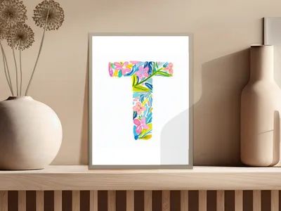 Colorful floral letter T art print on a shelf with vase.