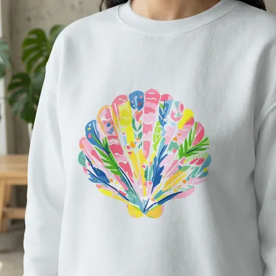 White sweatshirt with colorful seashell illustration in pink, blue, and green.