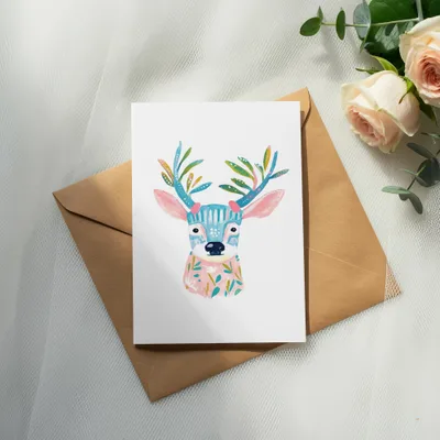 Colorful illustrated deer card with floral accents on a brown envelope.