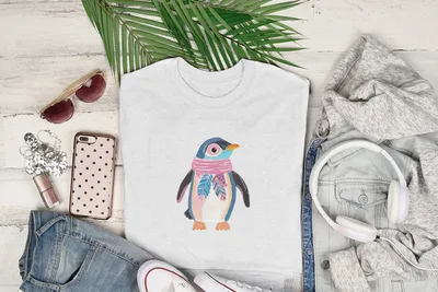 White t-shirt with a colorful cartoon penguin wearing a pink scarf.