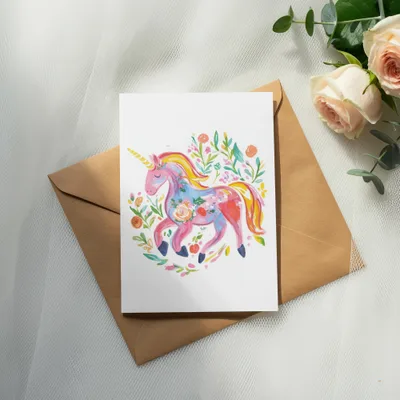 Card featuring a watercolor unicorn with floral accents on a brown envelope.