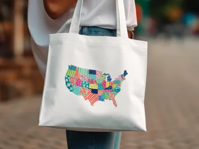 White tote bag with a colorful patchwork map of the United States.