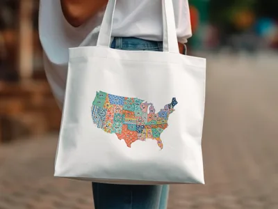 White tote bag with a colorful map of the United States on it.