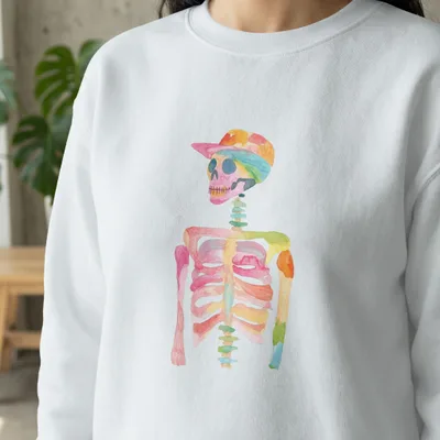 Watercolor skeleton wearing a colorful baseball cap on a white sweatshirt.
