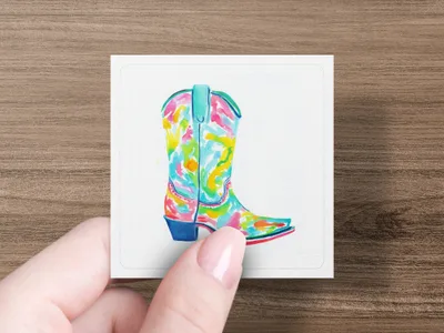 Colorful watercolor cowboy boot on white card held by fingers.