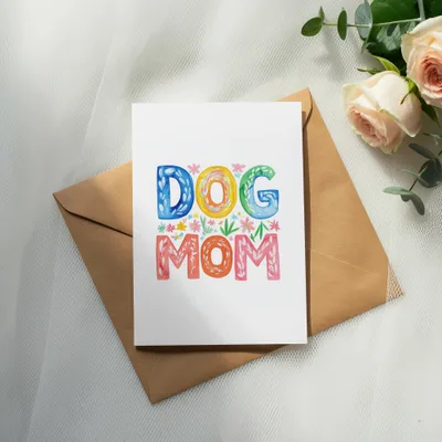 Card with "DOG MOM" in colorful letters on envelope, with roses and eucalyptus.