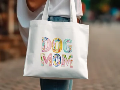 White tote bag with "DOG MOM" in colorful floral letters.