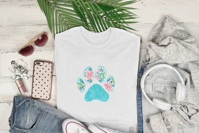 White t-shirt with teal paw print design featuring pink flowers.