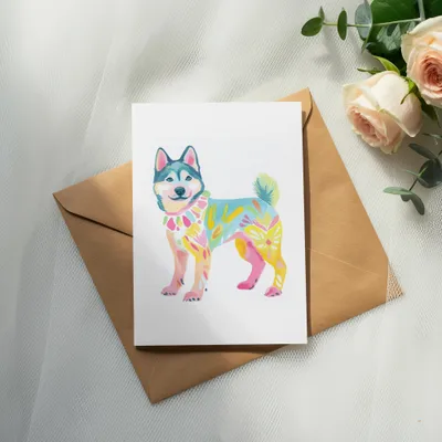 Watercolor painting of a colorful, abstract dog on a card with a brown envelope.