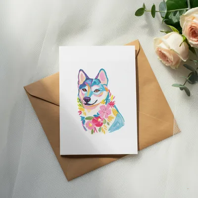 Colorful painted husky wearing a flower collar on a white card.