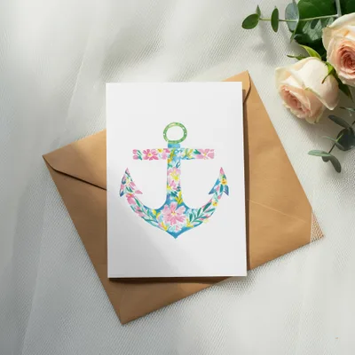 Watercolor anchor with pink and blue flowers on a card with a brown envelope.