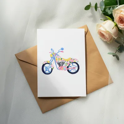 Watercolor motorcycle illustration on a card with roses and eucalyptus.
