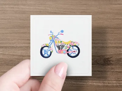 Floral-patterned motorcycle illustration on a square card held by a hand.