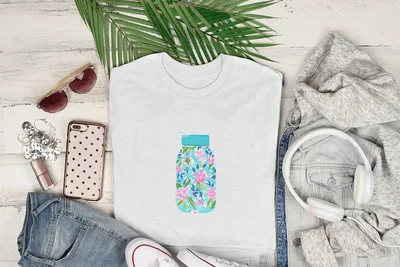 White t-shirt with blue jar graphic featuring pink and green floral pattern.