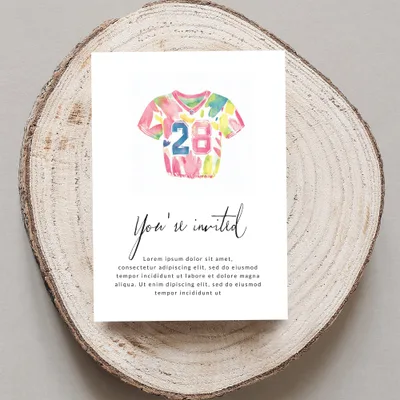 Watercolor jersey with "28" and "You're invited" text on a wood slice.