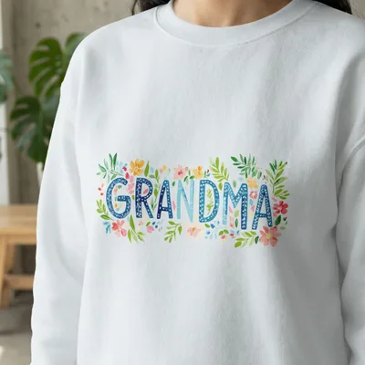 White sweatshirt with "GRANDMA" in floral watercolor lettering.