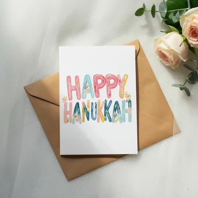 Card with "Happy Hanukkah" text in colorful letters on an envelope.