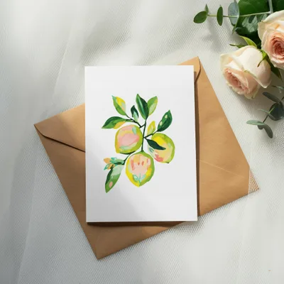Illustration of lemons on a card atop a kraft envelope with roses.