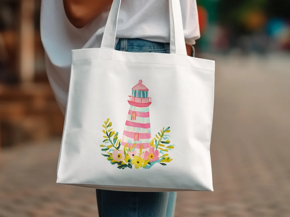 White tote bag with a pink and white striped lighthouse illustration and floral accents.