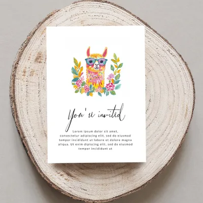 Card with illustrated llama and "You're invited" text on wood slice.