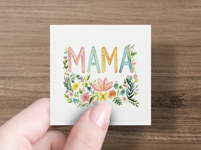 Card with colorful floral "MAMA" lettering held by fingers.