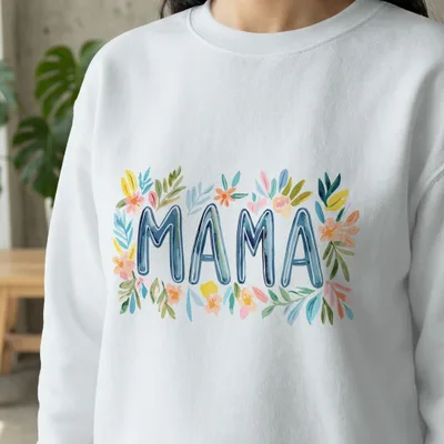 White sweatshirt with "MAMA" in watercolor floral letters.
