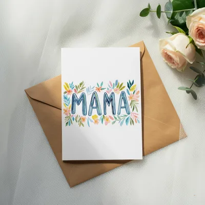 Greeting card with "MAMA" written in colorful watercolor flowers on an envelope.