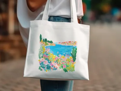 White tote bag with a colorful watercolor landscape of a coastal town.