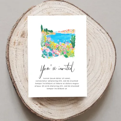 Watercolor invitation card with "You're invited" and floral seaside scene.