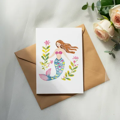 Greeting card featuring a watercolor illustration of a mermaid with floral accents.